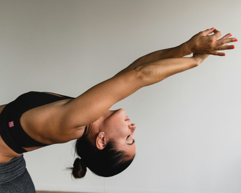 Woman practicing yoga stretch indoors, promoting wellness and balance