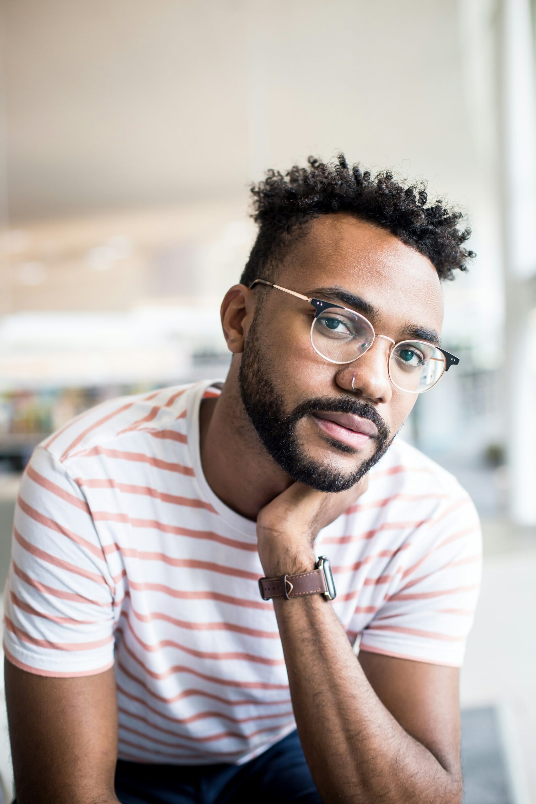 Young man with glasses giving a confident look, representing a satisfied Peptide Therapy client