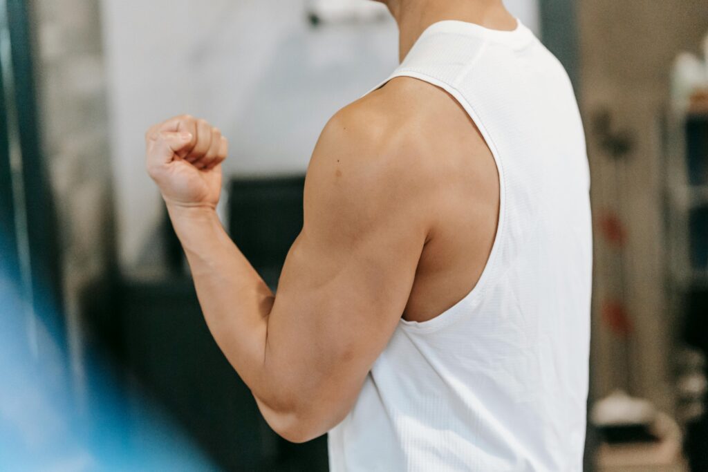 Close-up of strong male arm flexing, symbolizing Tesamorelin body-shaping benefits