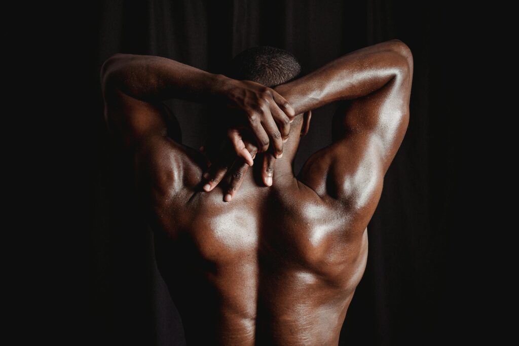 Strong athletic man stretching back muscles